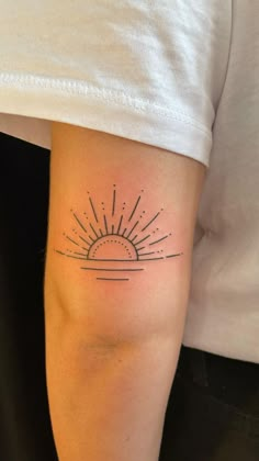 a person with a sun tattoo on their arm