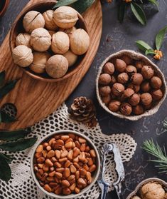 nuts and pine cones in bowls on a table