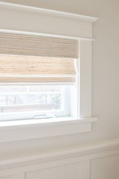 a white room with a window covered in blinds