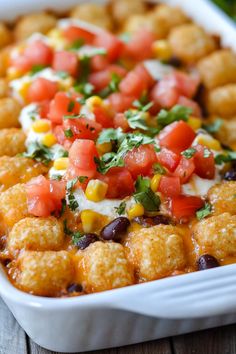 a casserole dish filled with corn, black beans and tomato garnish