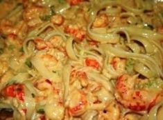 some noodles and shrimp are mixed together in a sauce that is ready to be eaten