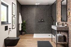 a bathroom with a brick wall and wooden flooring next to a white bathtub