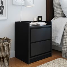 a night stand with two drawers and a lamp next to it on a wooden floor