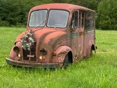 an old rusted out bus is sitting in the grass