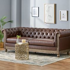 a brown leather couch sitting on top of a hard wood floor next to a table