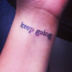 a small wrist tattoo with the words keep going on it's left side arm