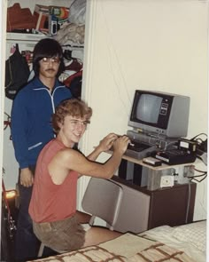 two young men standing next to each other in front of a tv and sound equipment