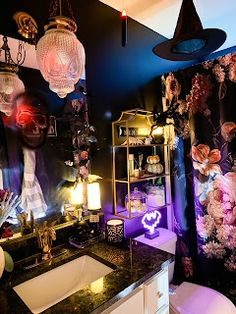 a bathroom decorated for halloween with decorations and lights on the wall above the sink area