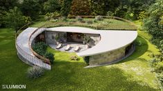 an aerial view of a circular house in the middle of a field with trees around it