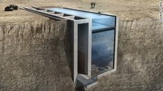 an unusual house built into the side of a cliff with people standing on top of it