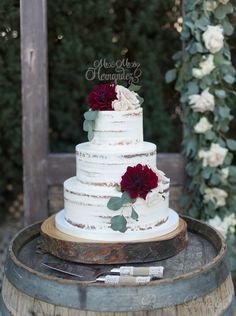 a wedding cake sitting on top of a barrel