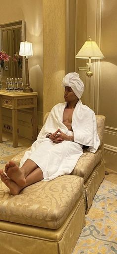 a woman sitting on top of a bed in a hotel room next to a mirror