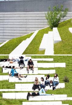 several people are sitting on white steps in front of a building with grass growing up the side