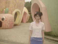 a young woman standing in front of a fake house with an animal head on it