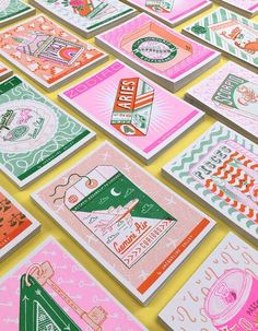 many different colored cards are arranged on the floor with pink and green designs in them