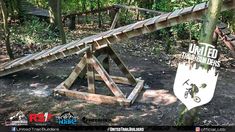 a man riding a dirt bike on top of a wooden ramp in the woods next to trees