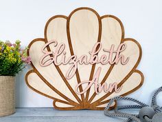 a wooden sign with the words elizabeth avenue on it next to some flowers and rope