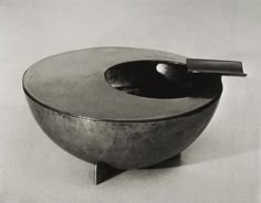 a black and white photo of a bowl with a spoon in it's center