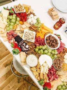 a platter filled with meats, vegetables and crackers on top of it