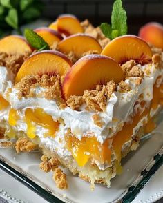 a dessert with peaches and whipped cream on top is sitting on a glass platter