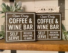 two signs are sitting on a shelf next to each other, one has a coffee and wine bar sign