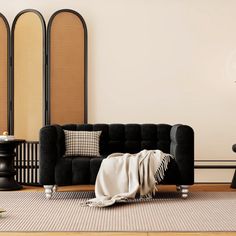 a living room with two black couches and a table in front of the wall