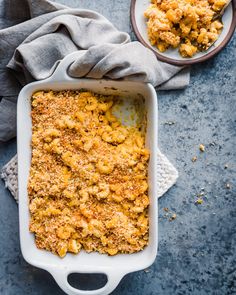 a casserole dish filled with macaroni and cheese on a blue surface