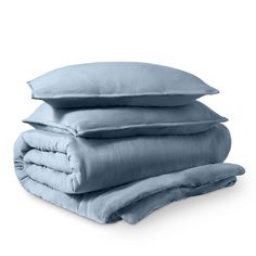 three pillows stacked on top of each other in front of a white background with blue sheets