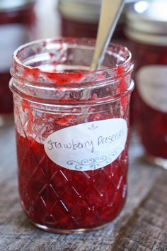 a jar filled with cranberry preserve sitting on top of a wooden table