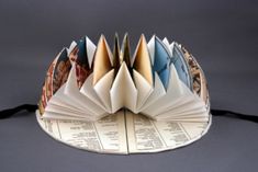 an open book with pages folded in the shape of a crown