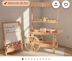 a wooden cart with cupcakes and pastries on it next to a sign