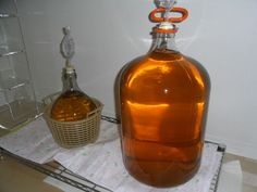 a brown glass bottle sitting on top of a counter next to a basket and knife