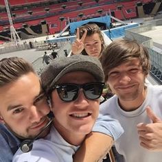 three men taking a selfie in front of an empty stadium