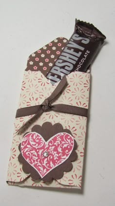 a candy bar wrapped in brown and pink paper with a heart on the wrapper