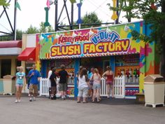 several people standing in front of a slush factory with colorful paint on the walls