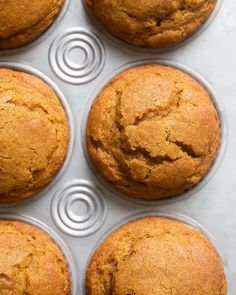 six muffins in a cupcake pan on a counter top with one missing