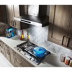 a stove top oven sitting inside of a kitchen next to wooden cupboards and counter tops