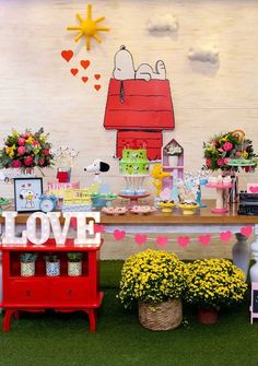 a table topped with lots of cake next to potted plants and other decor items