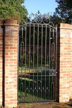 an iron gate in front of a brick wall