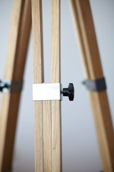 a close up of a wooden tripod with a metal bar on it's end