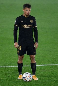 a man standing on top of a field next to a soccer ball and wearing yellow socks