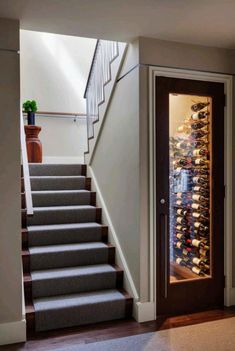 stairs leading up to a wine cellar in a home with carpeted flooring and white walls