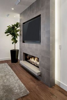 a living room with a flat screen tv mounted on the wall and a fireplace in it