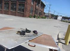 a table with some tools on it in the middle of an empty parking lot next to a building