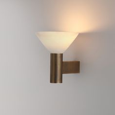 a wall light with a white glass shade on it