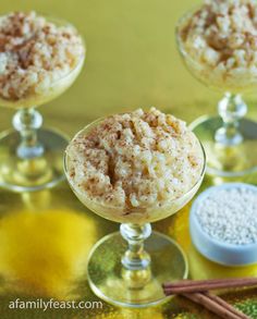 three desserts in small glass dishes on a yellow tablecloth with cinnamon sticks next to them