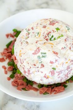 a large cheese ball sitting on top of a white plate