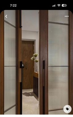 an open door leading to a hallway with glass panels on the front and back doors