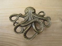 an octopus brooch sits on a wooden surface