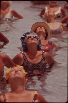 several people in the water with hats and sun glasses